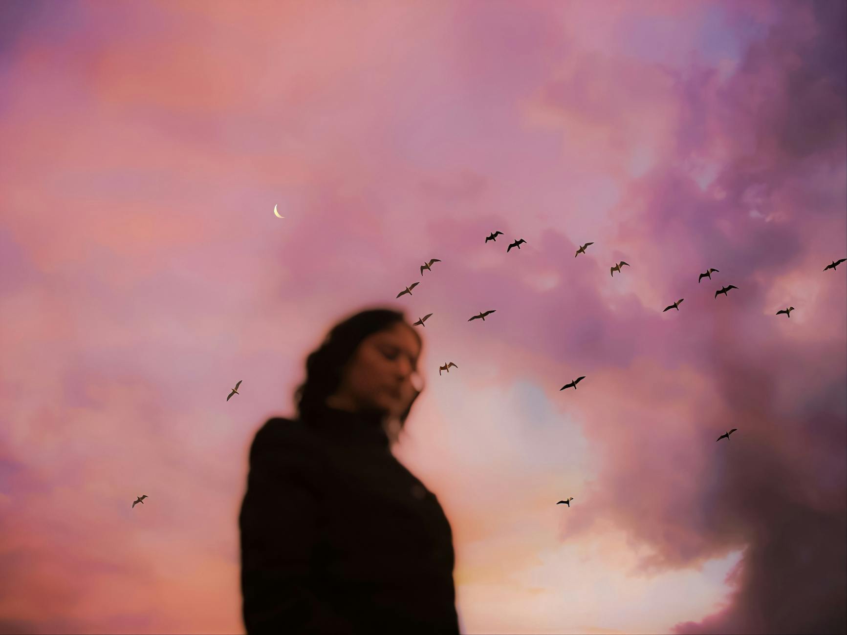 Blurry silhouette of person with birds flying and crescent moon in vibrant pink sky at sunset.